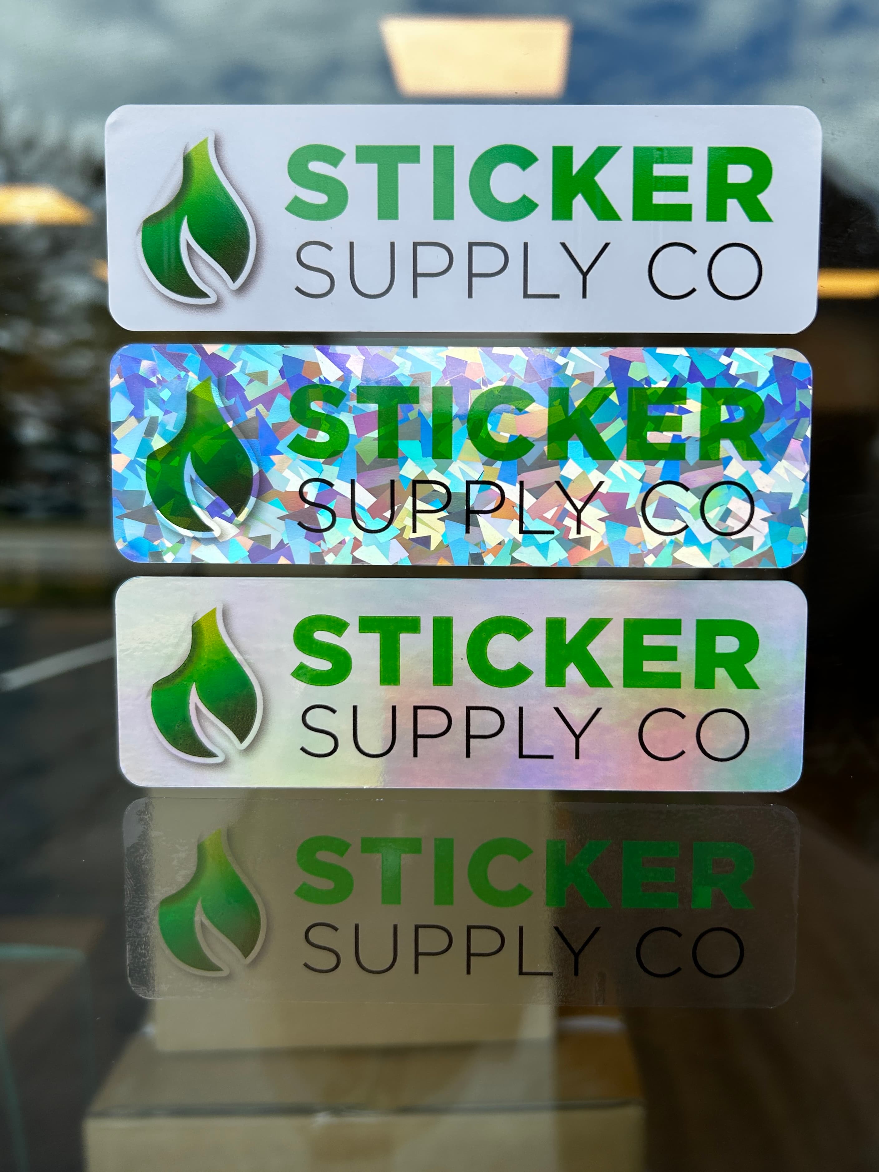 Sticker Supply Co vinyl samples in white, holographic glitter, and iridescent finishes